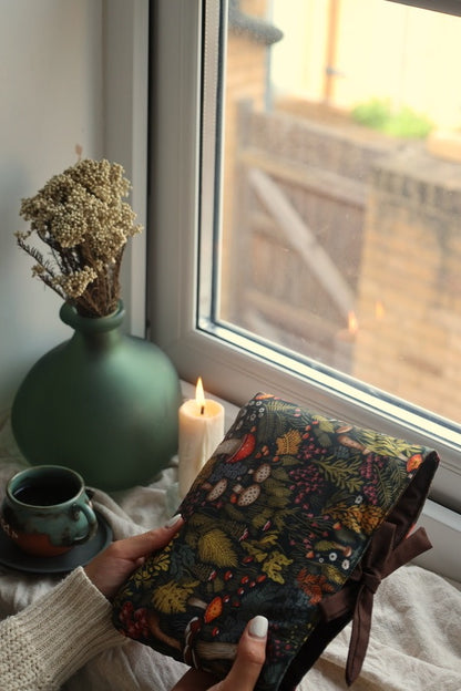 Reader holding book sleeve and preloved mystery book UK forest design.