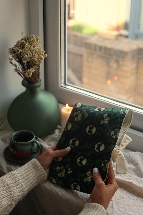 Reader holding book sleeve and preloved mystery book UK green butterfly design 