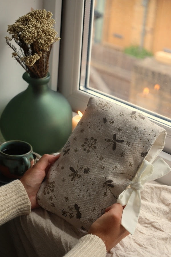 Reader holding book sleeve and preloved mystery book UK floral design.